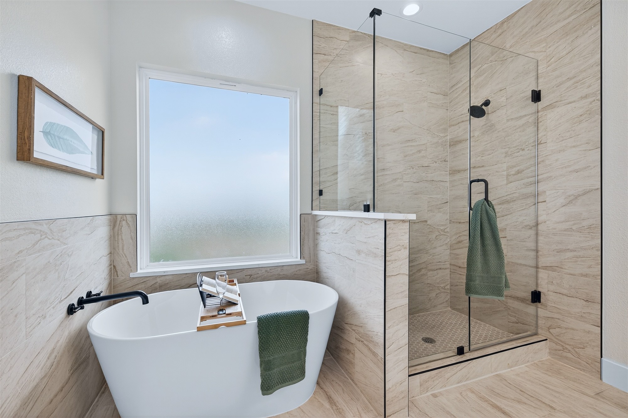 Finished bath with a freestanding tub and a marble-look tiled shower